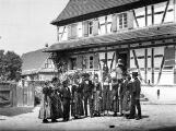 1 vue  - Oberseebach, jeunes gens en tenue traditionnelle dans la cour d\'une ferme. (ouvre la visionneuse)