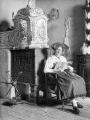 1 vue  - Portrait d\'une alsacienne assise devant un poêle en faïence (ouvre la visionneuse)