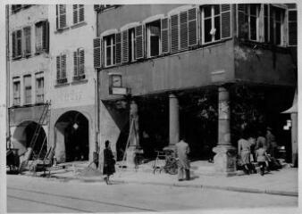 1 vue  - Rue des Grandes Arcades à hauteur du n°87, horlogerie E. Holtz, arcades et colonnes du passage, passants. [1940-1944]. (ouvre la visionneuse)