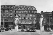 1 vue  - Place Kléber, bâtiment abritant le \'Elsaessischer Hilfdienst\', ornements et drapeaux nazis, véhicules automobiles. (ouvre la visionneuse)