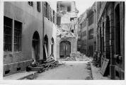 ouvrir dans la visionneuse : Rue de l'Epine, dégâts et décombres des bâtiments suite au bombardement aérien du 11 août 1944.