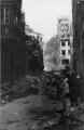 ouvrir dans la visionneuse : Rue du Fossé-des-Tailleurs vers la rue des Hallebardes, dégâts et décombres des bâtiments suite au bombardement aérien du 11 août 1944.