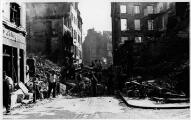 ouvrir dans la visionneuse : Rue Gutenberg à l'angle de la Rue du Miroir, immeubles éventrés, décombres.